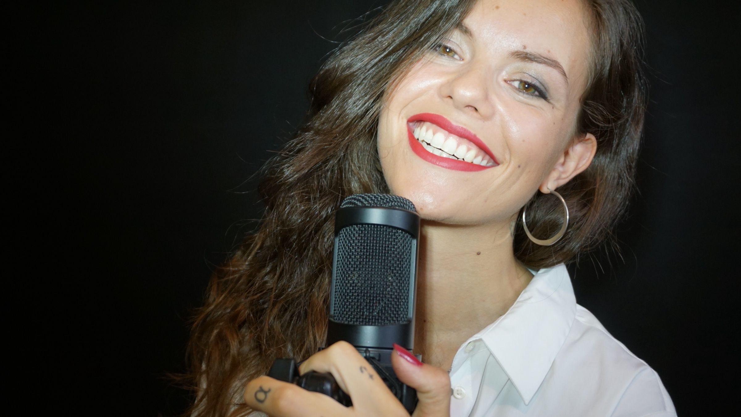 Orlean B sonriendo con un micrófono de estudio